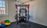 A male model using the CTX5 as a squat rack